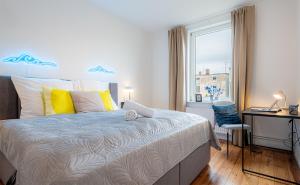 a bedroom with a bed and a desk and a window at Sadebo Apartments Wave 6 Gäste 2 Schlafzimmer 1 Wohnzimmer in Lübeck