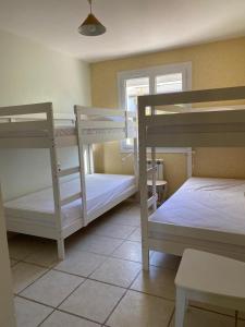 a room with two bunk beds and a window at Belle villa spacieuse avec piscine privée, semi climatisée- 10 couchages, wifi, proche canal du midi et à 4 km de la mer LXPIN7 in Portiragnes +37 photos