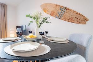 a dining room table with plates and wine glasses at Sadebo Apartments Wave 6 Gäste 2 Schlafzimmer 1 Wohnzimmer in Lübeck