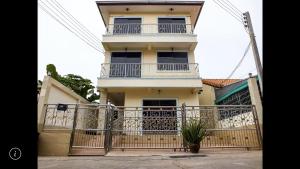 a white house with a balcony and a fence at Junior apartment in Pattaya +3 photos