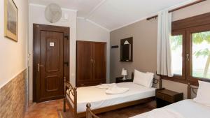 a bedroom with two beds and a window at Katerina-Maria Studios & Apartments in Vourvourou +27 photos