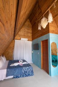 un letto in una stanza con soffitto in legno di Solita beach bungalow - kite spot a Macau