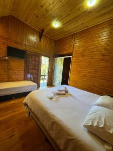 a bedroom with two beds in a wooden room at Refúgio dos Platanus in Campos do Jordão