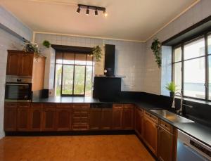a kitchen with wooden cabinets and black counter tops at PERLA ETXEA in Elizondo