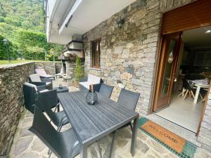 a wooden table and chairs on a patio at Appartamento Giulio in Cannobio