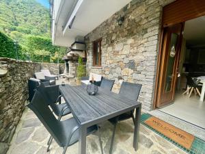a wooden table and chairs on a patio at Appartamento Giulio in Cannobio