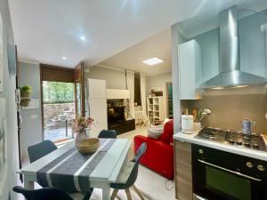 a kitchen and living room with a table and a red couch at Appartamento Giulio in Cannobio +34 photos