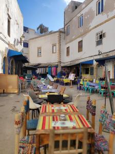 Un grupo de mesas y sillas en un patio. en Riad de charme l'Oasis d'Essaouira - Chambre Luxe, en Essaouira