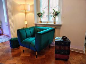 a green chair in a living room with a window at Exklusive Ferienwohnung Agnes in zentraler Bestlage von Zeitz! Vollausgestattet, freie Parkplätze, Magenta-TV, Highspeed WLAN, Fahrstuhl in Zeitz