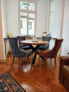 a dining room with a wooden table and chairs at Exklusive Ferienwohnung Agnes in zentraler Bestlage von Zeitz! Vollausgestattet, freie Parkplätze, Magenta-TV, Highspeed WLAN, Fahrstuhl in Zeitz