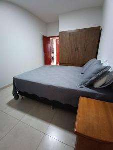 una camera da letto con un letto grande con testiera in legno di Aconchego 2 a Dourados