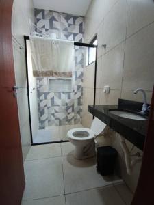 un bagno con doccia, WC e lavandino di Aconchego 2 a Dourados