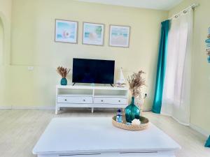 una sala de estar con TV en una cómoda blanca en Sweet Home Apartman, en San Miguel de Abona