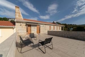 two chairs and a table on a patio with a church at Casa do Casal do Douro in Marco de Canavezes