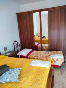 a bedroom with two beds and a mirror at B&B da Natallia in Ronco allʼAdige