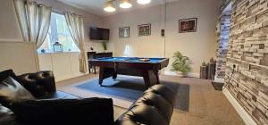 a living room with a pool table and leather furniture at Antfield House in Inverness