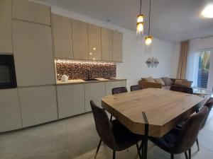 a kitchen and dining room with a wooden table and chairs at SPA house in Druskininkai