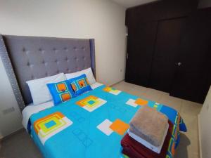a bedroom with a large blue bed with a headboard at Apto Familiar con Escritorio Fácil Acceso Turístico in Pereira