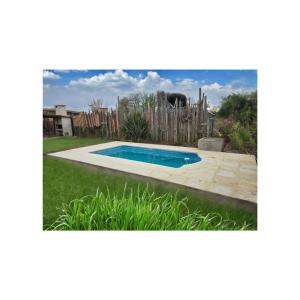 a swimming pool in a yard with a fence at Cabaña Suri in Belén de Escobar