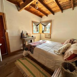 a bedroom with a bed and a table and windows at Cabaña Suri in Belén de Escobar