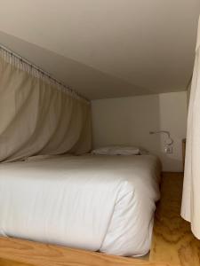 a bedroom with a white bed with a canopy at Surf & Sea Suites in Parede