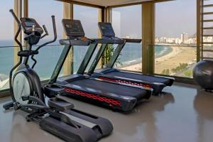 a gym with two exercise bikes and a view of the beach at PortoBay Rio de Janeiro in Rio de Janeiro