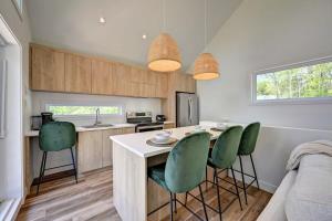 a kitchen with green chairs and a kitchen island at Le Petit Bijou in Sainte Béatrix