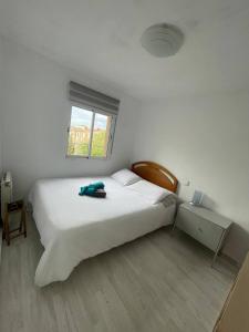 a white bedroom with a large white bed and a window at Piso con Vistas y Mucho Encanto in Madrid
