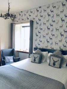 a bedroom with a bed and a wall with deer on it at The Drymen Inn in Drymen +13 photos