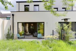 a white house with a courtyard with chairs at Maison Joseph - Chambre 1 in Saint-Jacques-de-la-Lande