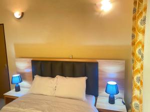 una camera con un letto e due lampade blu di BelleVille Residence a Bobo-Dioulasso