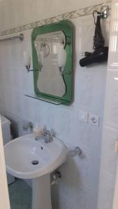 a bathroom with a sink and a mirror on the wall at Simos Apartment in Gjirokastër +22 photos
