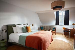 una camera da letto con un letto, un tavolo e delle sedie di La Closerie des Capucines ad Arbois