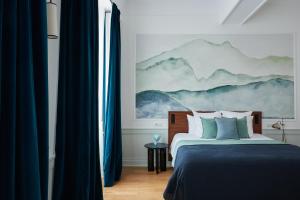 una camera da letto con letto e tende blu di La Closerie des Capucines ad Arbois