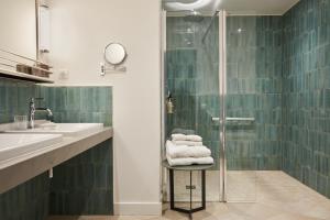 un bagno con doccia e asciugamani su uno sgabello di La Closerie des Capucines ad Arbois