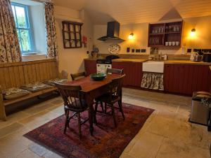 a kitchen with a wooden table and chairs in it at Goggin Cottage in New Kildimo
