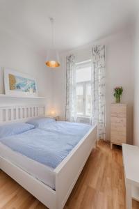 a white bedroom with a large bed and a window at Landhaus Blauer Spatz Reichenau an der Rax in Reichenau