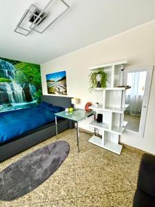 a bedroom with a blue bed and a table at Wolkenzimmer mit 140 cm Bett im Erdgeschoss in Seligenstadt
