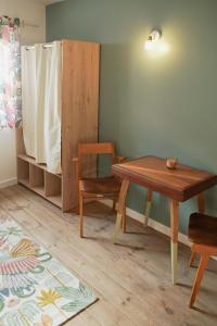 a room with a wooden table and a chair at Le Montarrouye Appartement pour 2 à 6 personnes in Bagnères-de-Bigorre +8 photos