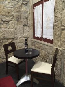 een tafel met 2 stoelen en een fles wijn bij Clerigos-H in Porto