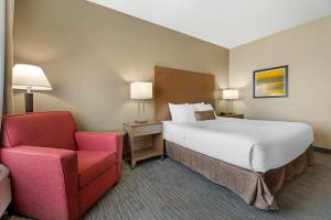ein Hotelzimmer mit einem Bett und einem Stuhl in der Unterkunft Best Western Plus Jefferson in Jefferson + 33 Fotos