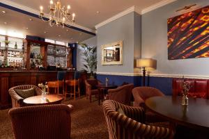 a restaurant with tables and chairs and a bar at Macdonald New Blossoms Hotel, Chester in Chester