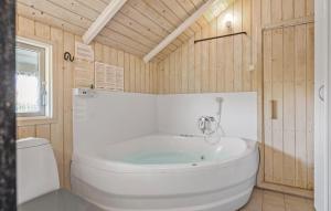 un bagno con una vasca bianca e un water di Beautiful Home In Bogense With Kitchen a Bogense