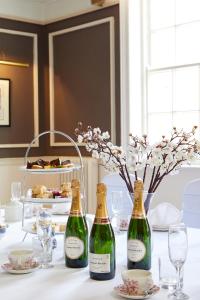 two bottles of wine on a table with glasses at Macdonald New Blossoms Hotel, Chester in Chester +33 photos