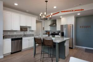 a kitchen with white cabinets and a island with chairs at Cinnabar Suite - Mountain Views in Bozeman