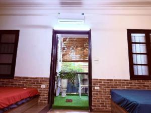 a room with two beds and a window at House with balcony,K Home 1,Old Quarter,3 mins to Hoankiem Lake in Hanoi