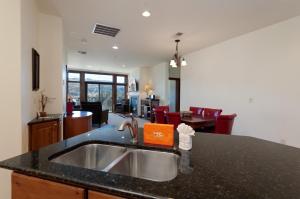a kitchen with a sink and a living room at Peregrine Point 204 in Durango Mountain Resort