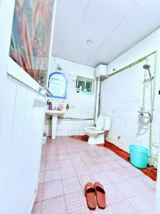 a bathroom with a toilet and a pair of slippers at House with balcony,K Home 1,Old Quarter,3 mins to Hoankiem Lake in Hanoi