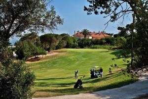 a group of people playing golf on a golf course at Vila Galé Estoril in Estoril