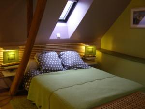 a attic bedroom with a bed with a skylight at gite rural de La Neuville Roy in La neuville roy